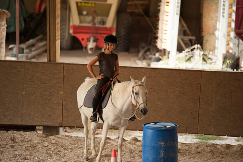 Une enseignante d'équitation fait une pause pendant une séance avec son cheval