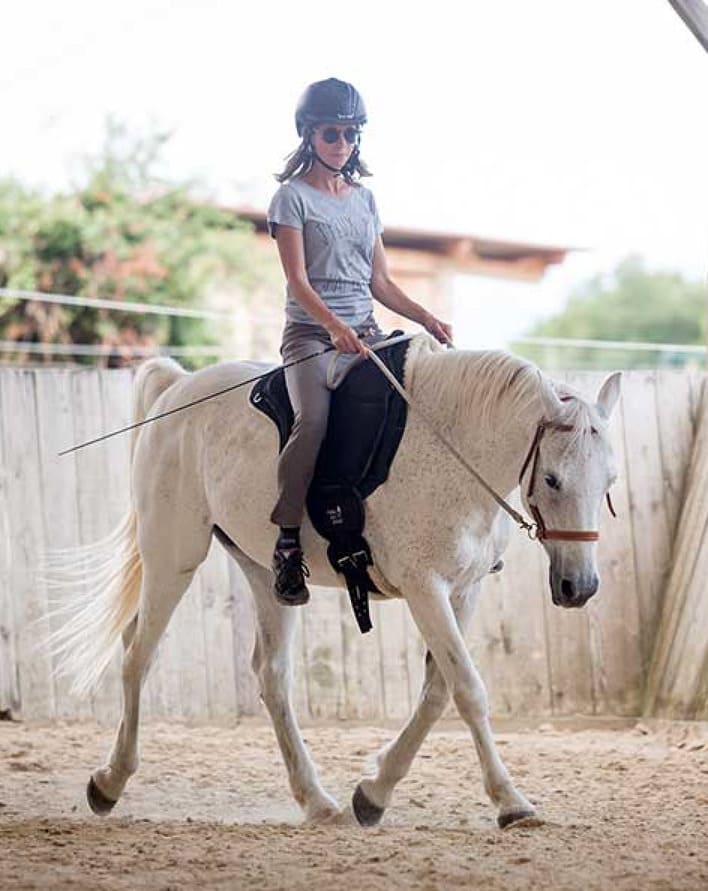 Femme sur cheval en séance d'équitation et de dressage